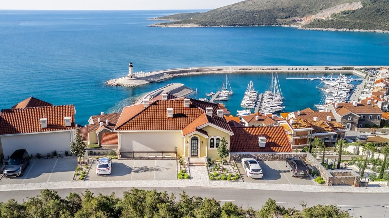 Aerial view of luxury villas in Luštica Bay, Radovići, Montenegro, with panoramic views of the marina and lighthouse.
