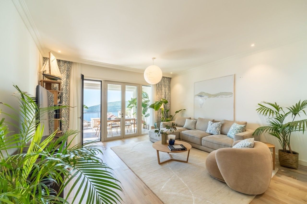 Bright living room in an apartment in Luštica Bay, Radovići, Montenegro: modern furniture, terrace with sea view.