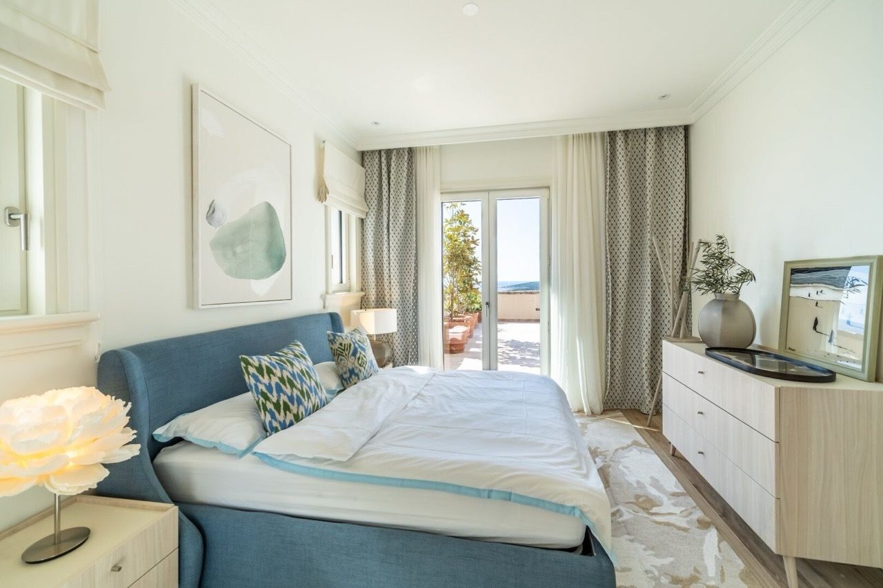 Bright bedroom in Lustica Bay apartments, Radovici, Montenegro: blue bed, sea view, and terrace.