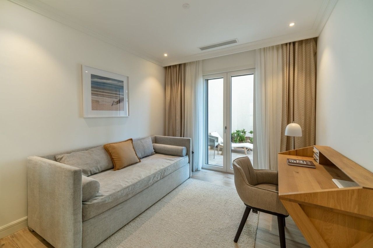 Cozy living room with a sofa and desk in an apartment in Lustica Bay, Radovici, Montenegro, with access to the terrace.