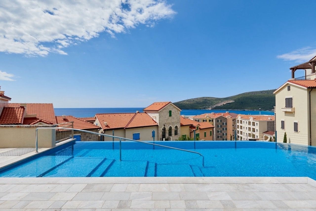 Open infinity pool with sea view and the Luštica Bay residential complex in Radovići, Montenegro.