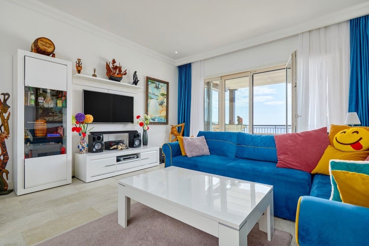 Bright living room with a blue sofa and sea view in an apartment in Luštica Bay, Radovići, Montenegro.