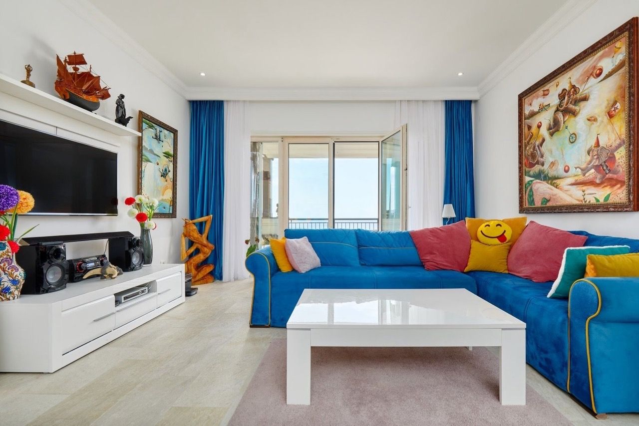 Bright living room with a blue sofa and sea view in an apartment in Luštica Bay, Radovići, Montenegro.