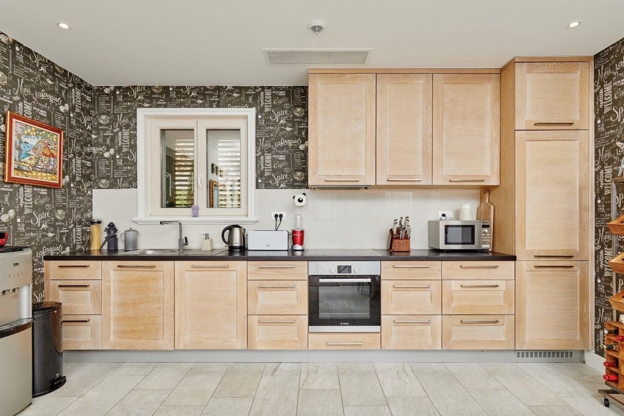 Modern kitchen with wooden fronts in an apartment in Luštica Bay, Radovići, Montenegro: built-in appliances and decor.