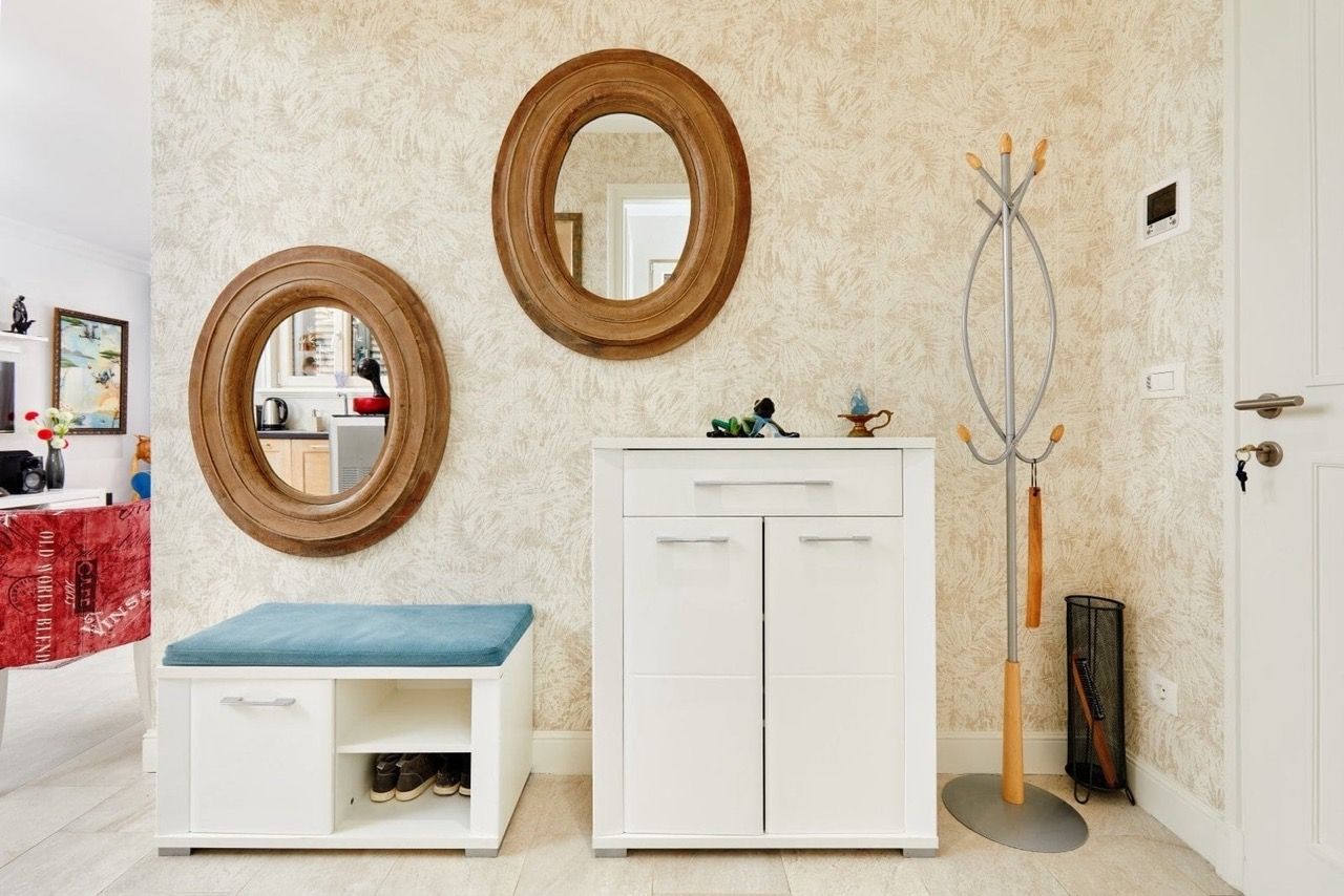 Hallway in an apartment in Lustica Bay, Radovici, Montenegro: white furniture, oval mirrors, and a coat rack.