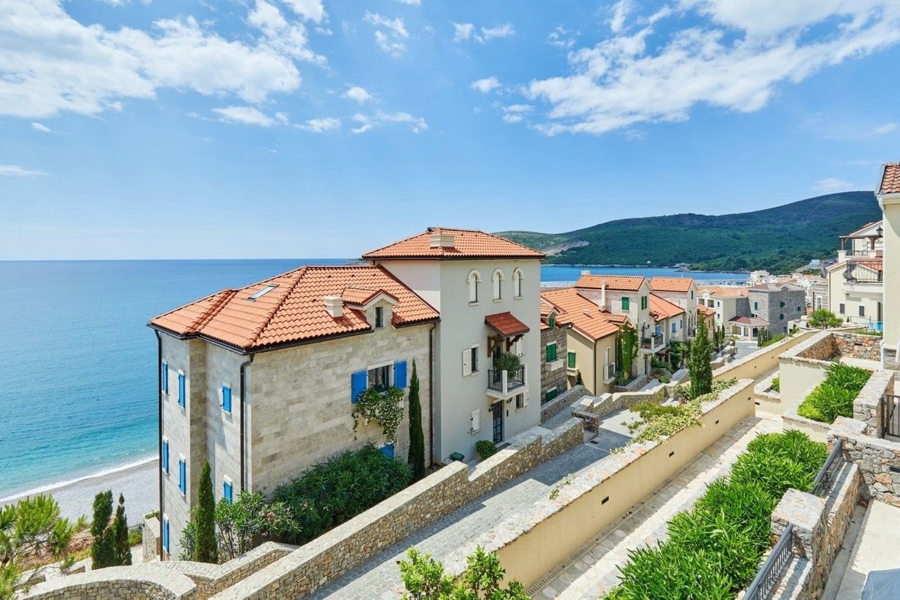 View of luxury villas with tiled roofs and the sea in the Luštica Bay residential complex, Radovići, Montenegro.