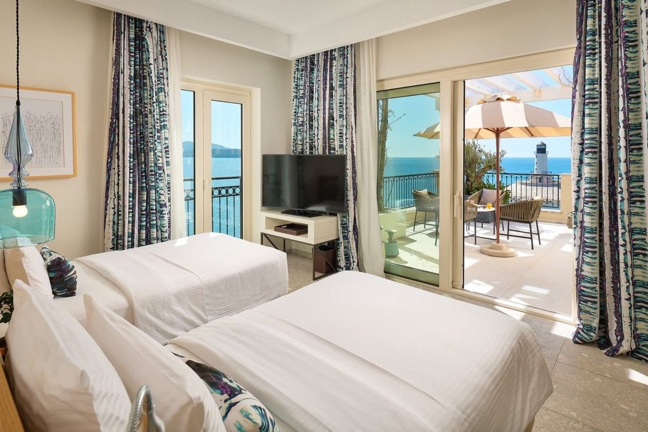 Bedroom in an apartment in Luštica Bay, Radovići, Montenegro, with access to the terrace and a view of the sea and lighthouse.