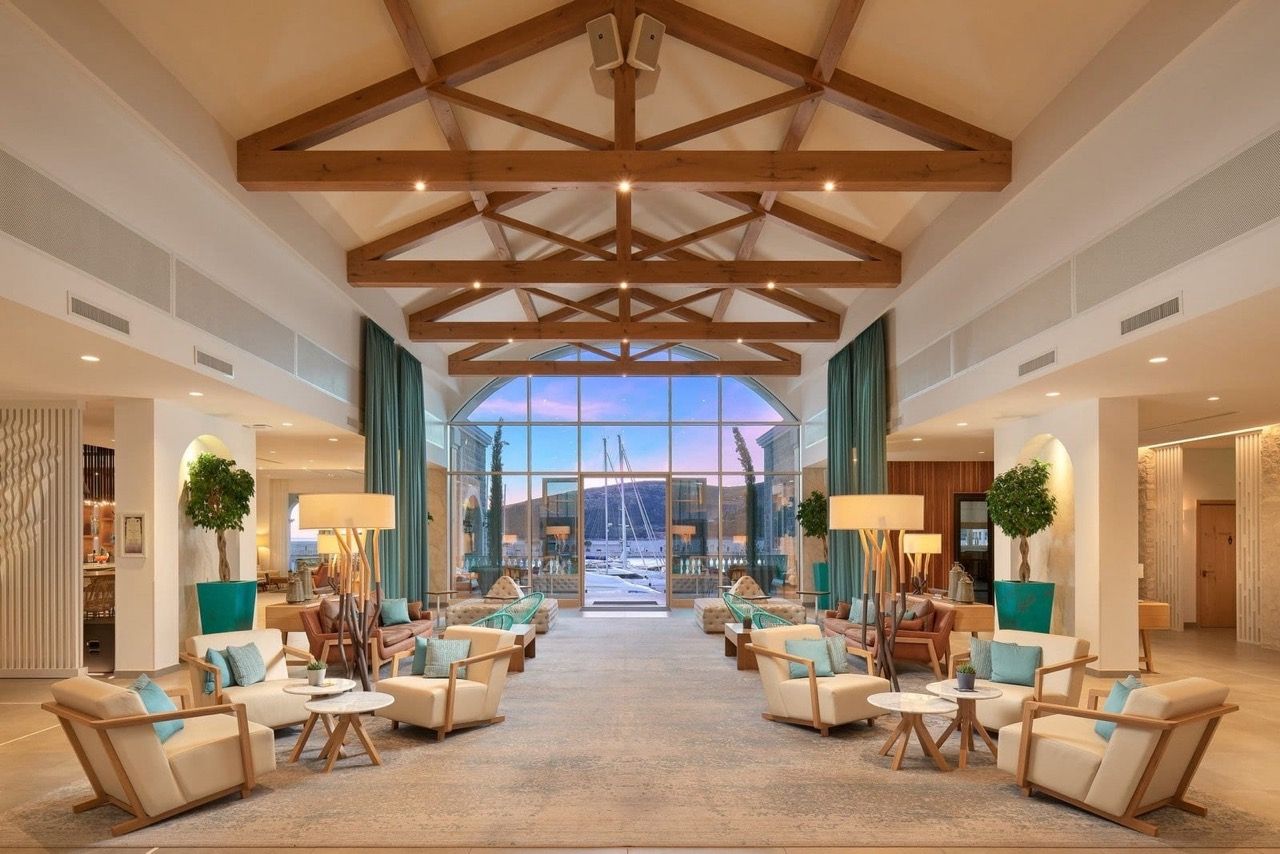 Living room interior with panoramic views of the marina in Luštica Bay, Radovići, Montenegro: wooden beams and cozy furniture.