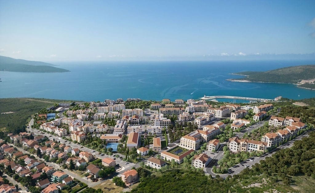 Aerial view of the Lustica Bay residential complex in Radovici, Montenegro: modern homes by the sea and a yacht marina.