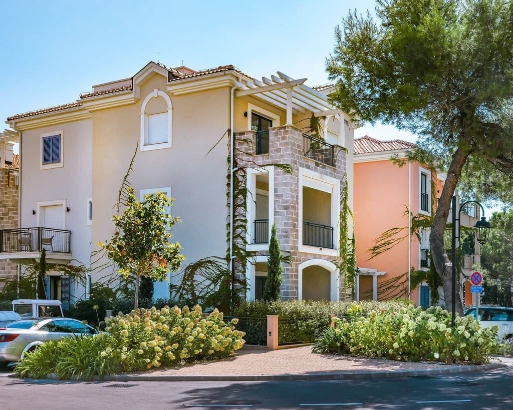 Facade of a residential complex in Luštica Bay, Radovići, Montenegro: modern architecture, balconies, and landscaping.