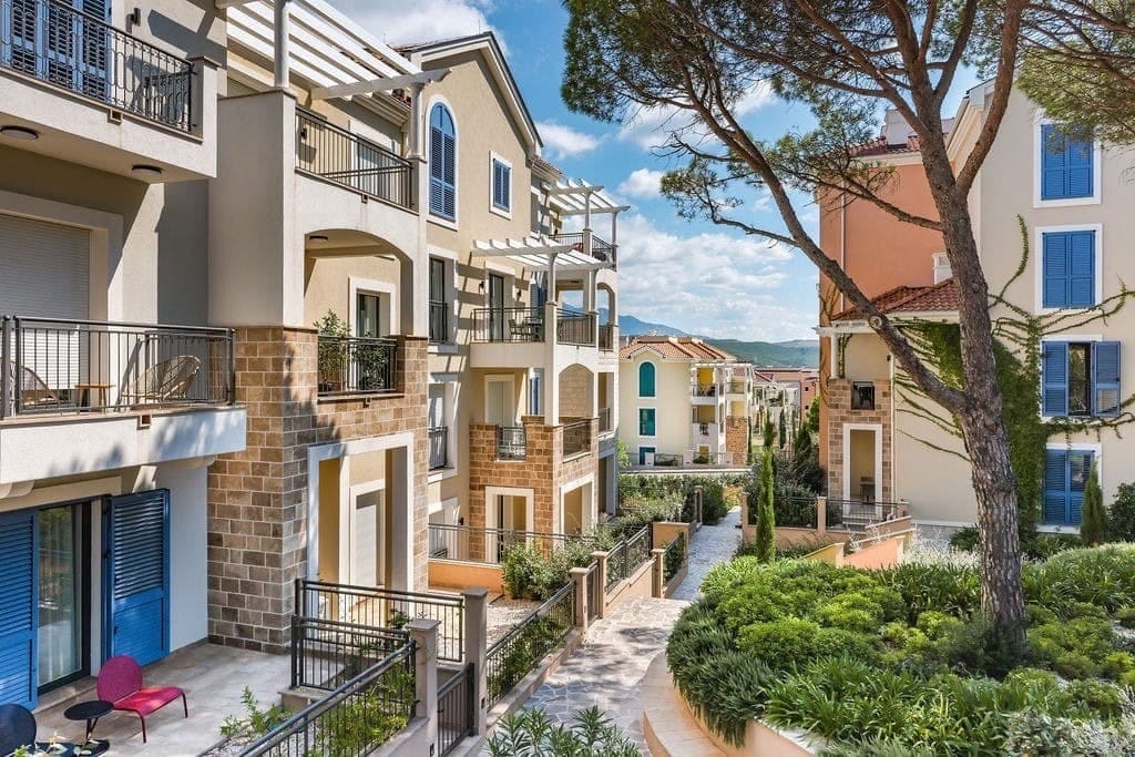 Modern residential complexes in Luštica Bay, Radovići, Montenegro: view of terraces, stone finishes, and landscaped garden.