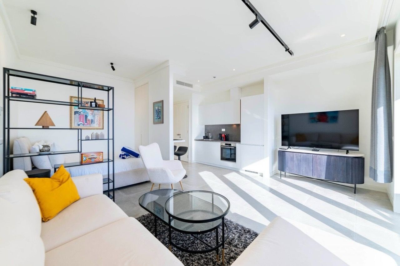 Modern living room with kitchen in Luštica Bay apartments, Radovići, Montenegro: bright interior, stylish furniture.