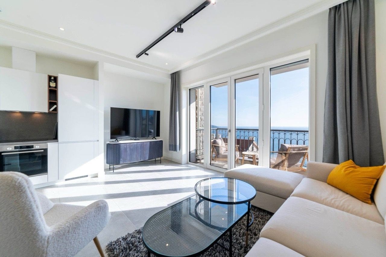 Modern living room with kitchen in an apartment in Luštica Bay, Radovići, Montenegro, with panoramic sea views and a terrace.