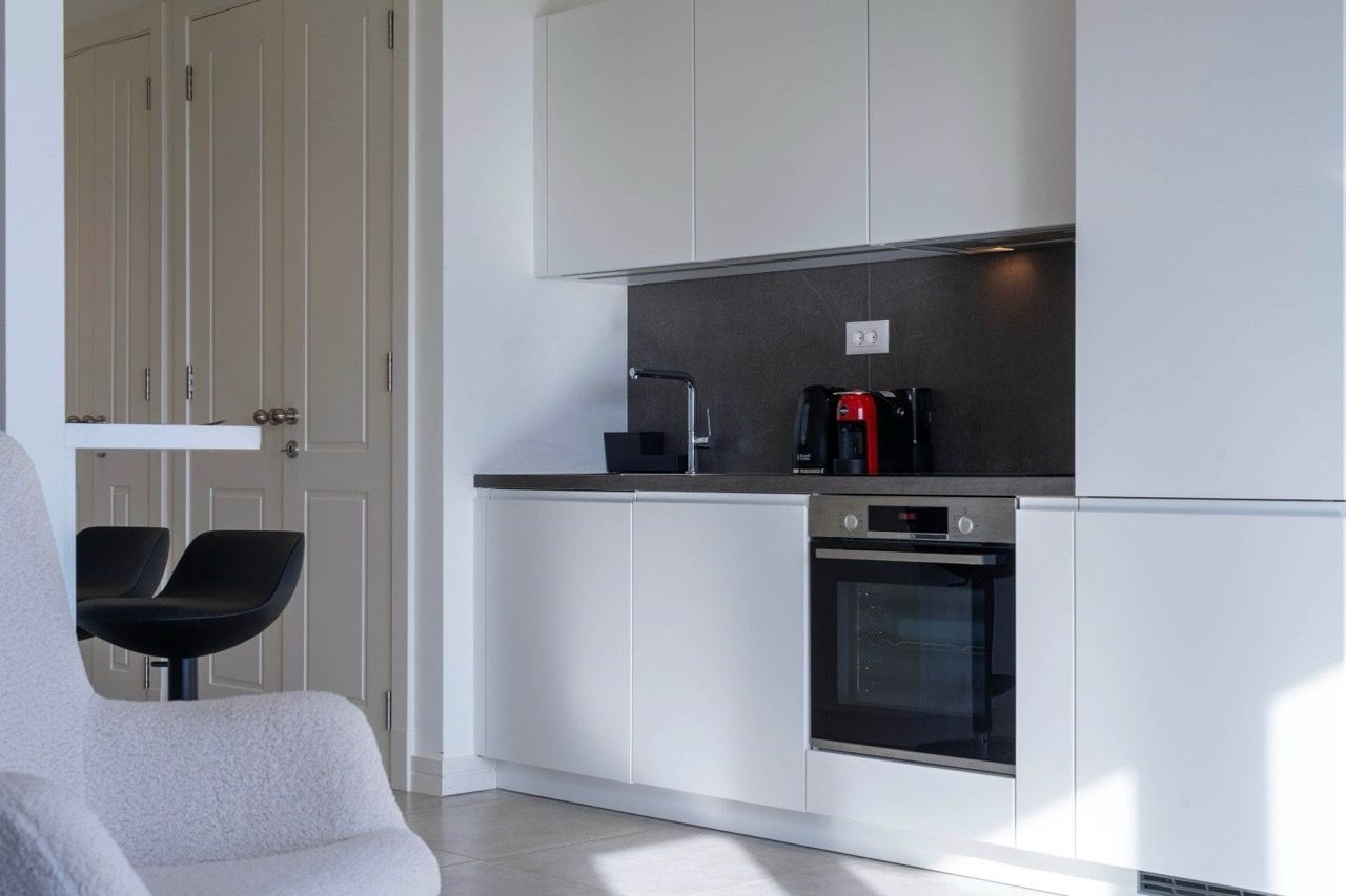 Modern white kitchen in a Lustica Bay apartment, Radovici, Montenegro: built-in appliances and stylish interior.