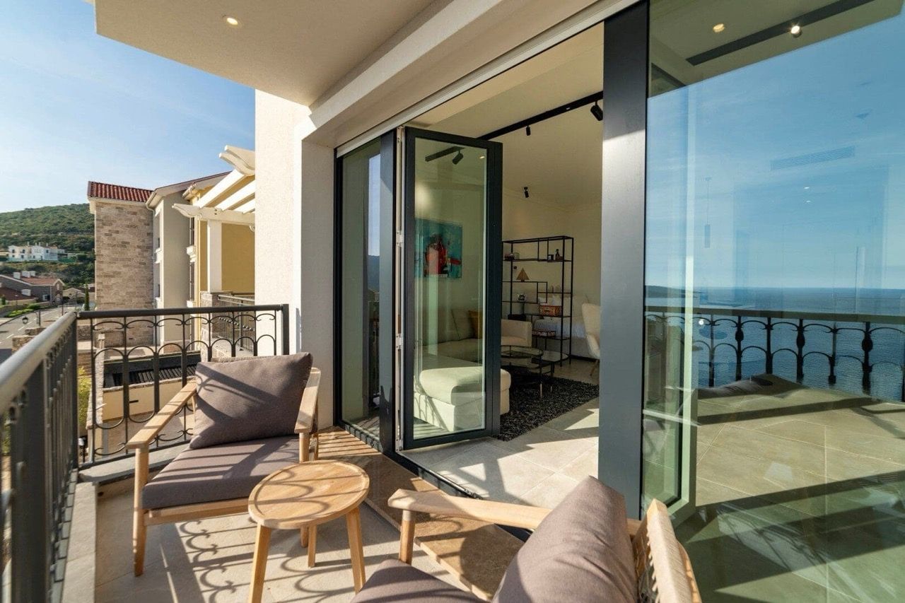 Balcony with furniture and panoramic sea view in an apartment in Luštica Bay, Radovići, Montenegro.