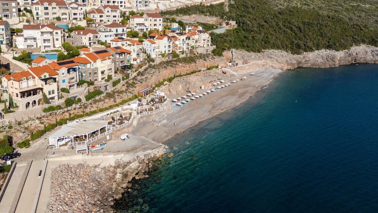 Aerial view of the Lustica Bay residential complex in Radovici, Montenegro: private beach, promenade, and seafront.