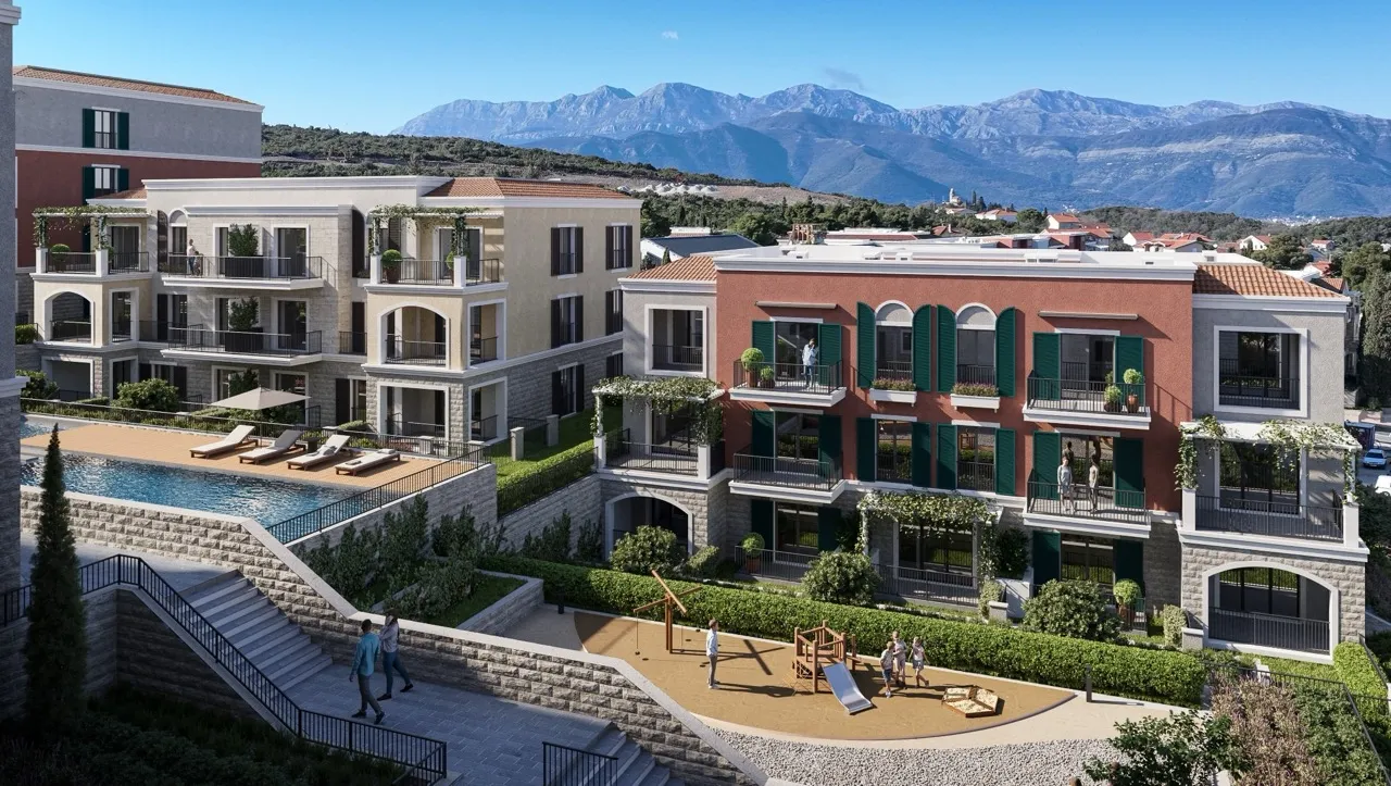 Exterior view of a residential complex featuring a pool, terraces, and playground against mountains.