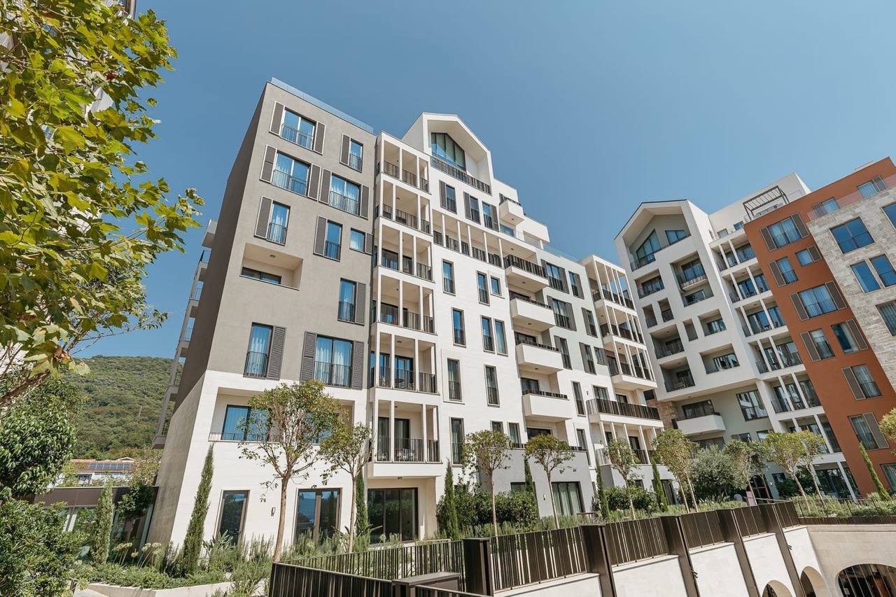 Modern residential complex in Porto Montenegro, Tivat, Montenegro: building facade with balconies and landscaping.