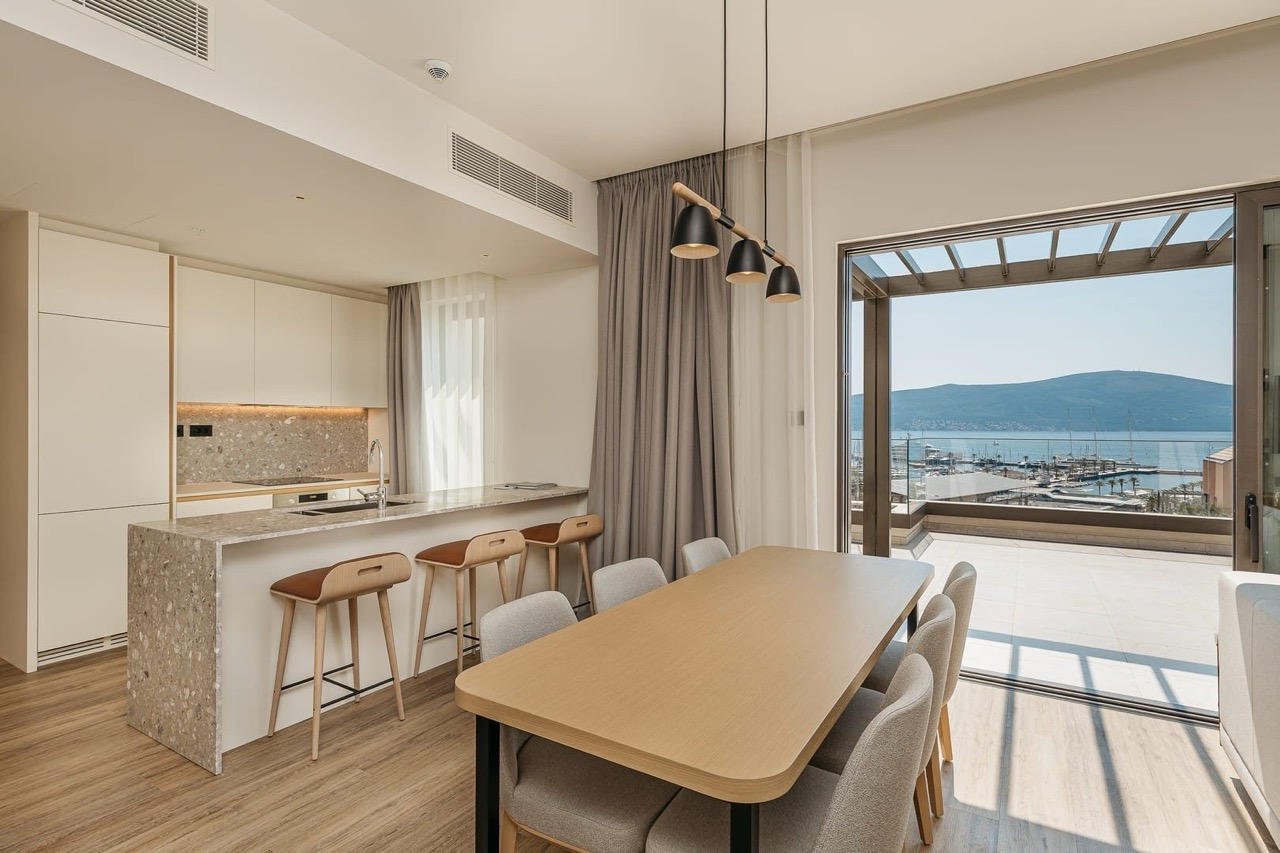 Modern living room with kitchen in Porto Montenegro, Tivat, Montenegro: marina view, terrace, and stylish furniture.