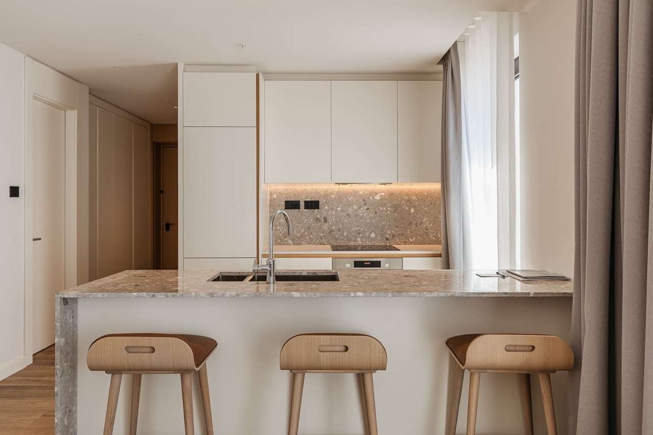 Modern kitchen with an island and bar stools in an apartment at Porto Montenegro, Tivat, Montenegro.