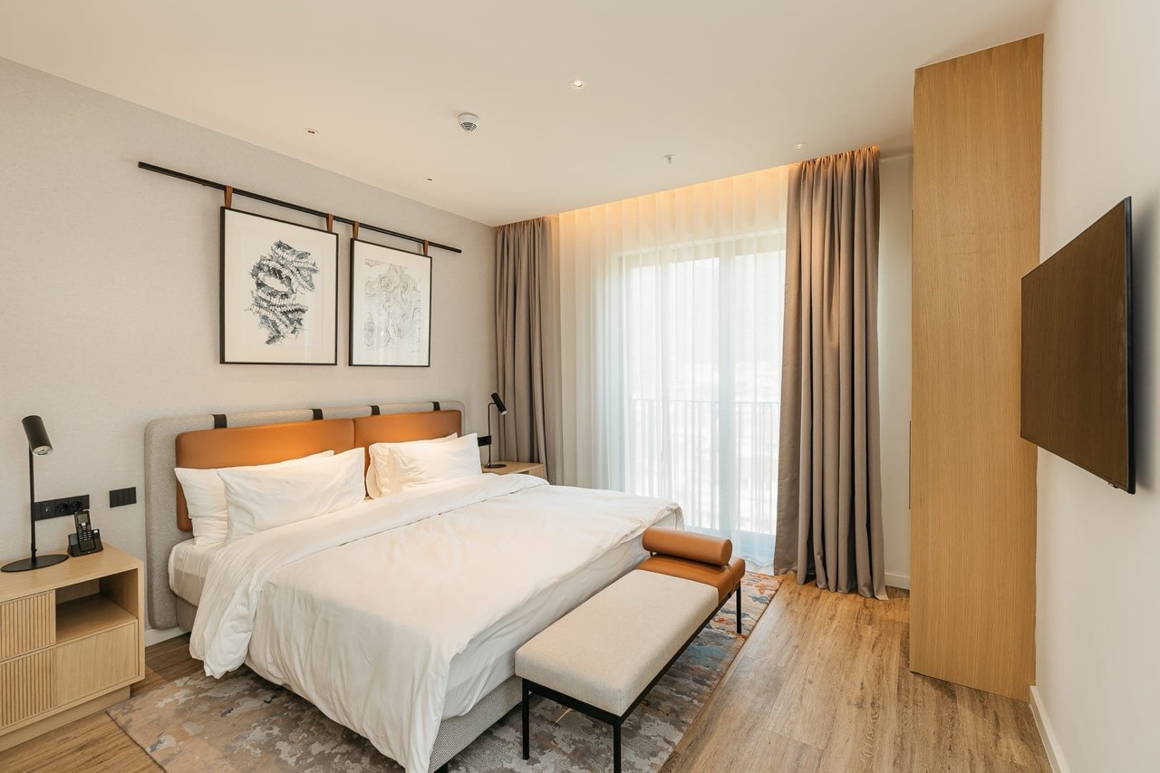 Modern bedroom in an apartment in Porto Montenegro, Tivat, Montenegro: double bed, bright interior, and TV.