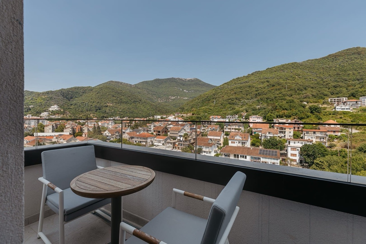 Balcony with furniture and panoramic views of the mountains and the city of Tivat in Porto Montenegro, Montenegro.
