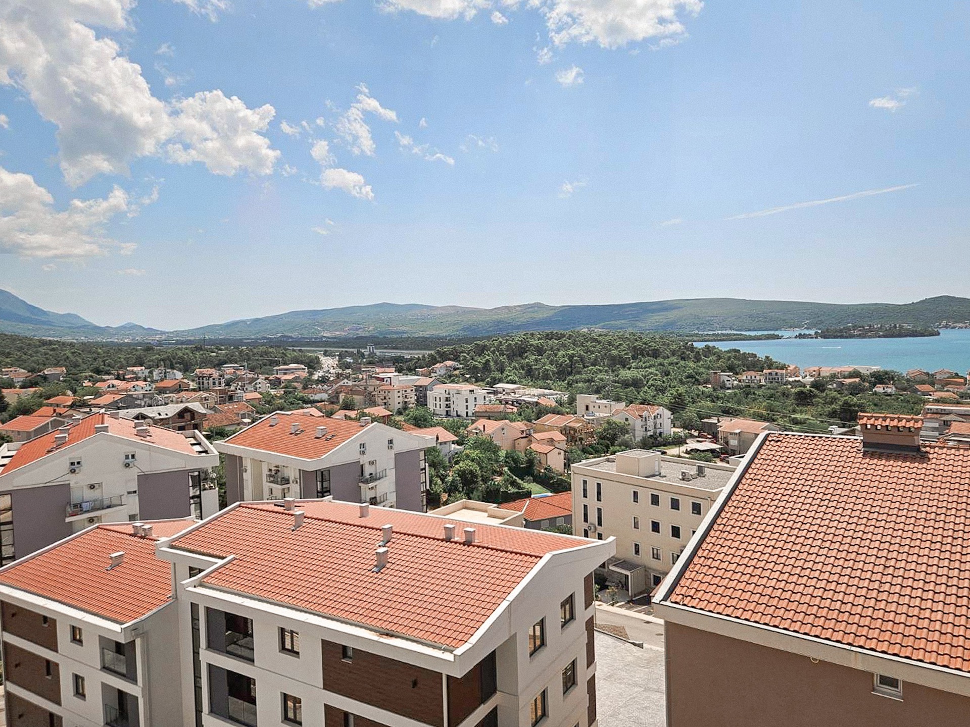 Panoramic view of Tivat and the Adriatic Sea from the apartment windows in Montenegro, modern houses with red tile roofs.