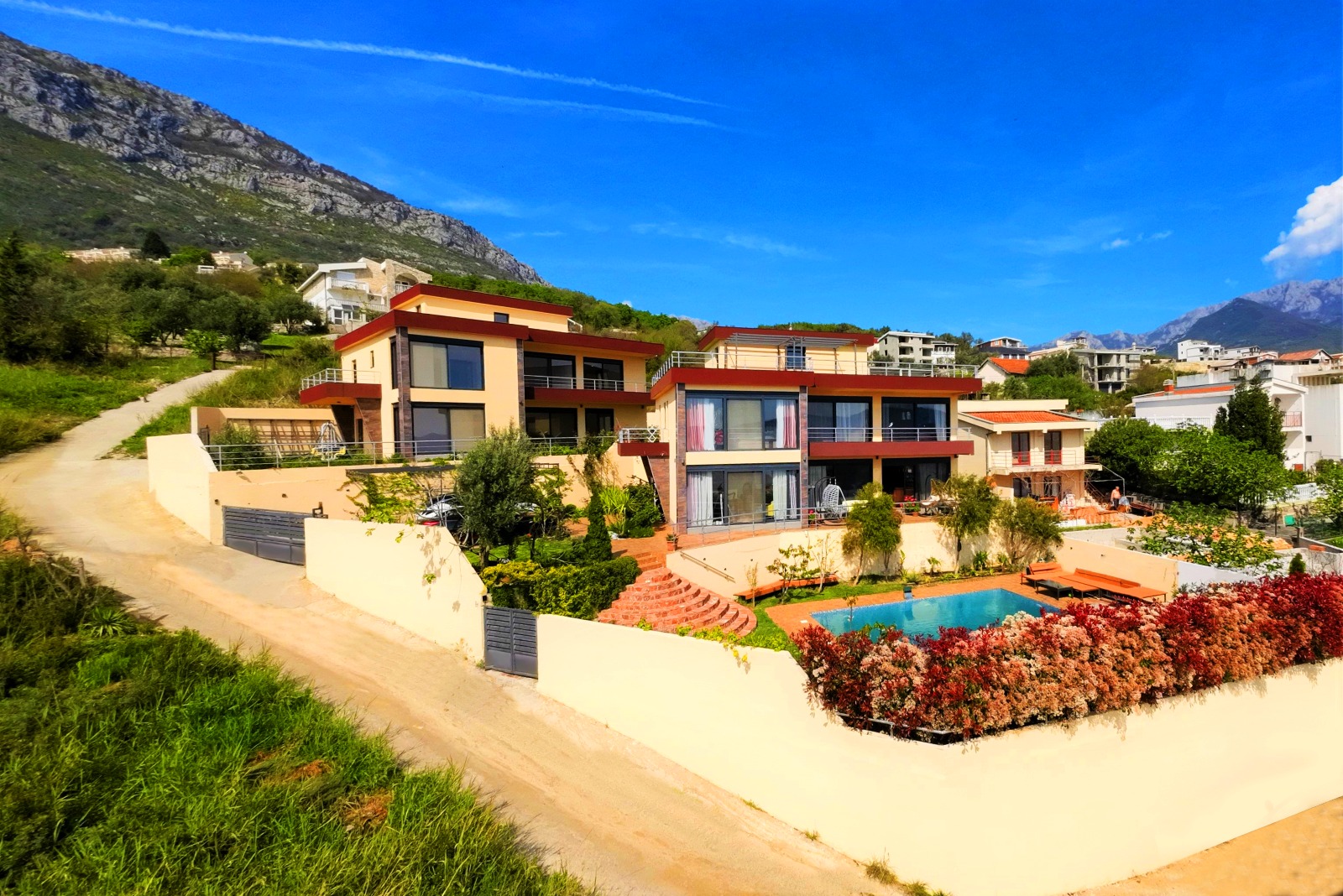 Modern villa in Bar, Montenegro: a two-story house with panoramic windows, a swimming pool, and landscape design.