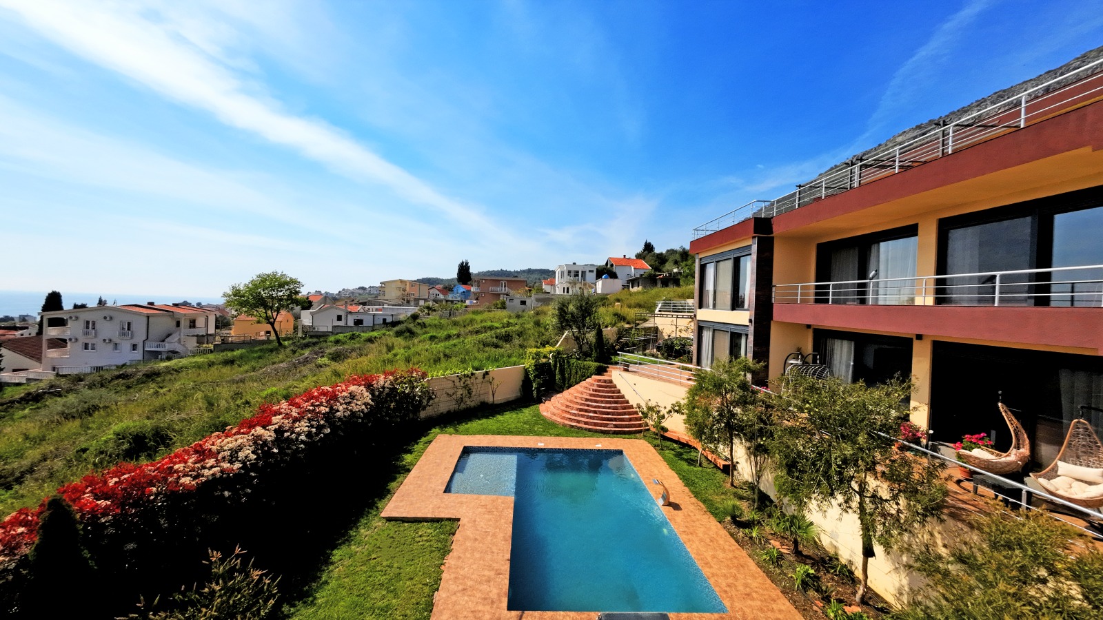 Modern villa with a pool and terrace in Bar, Montenegro: view of the house, garden, and coastal panorama.