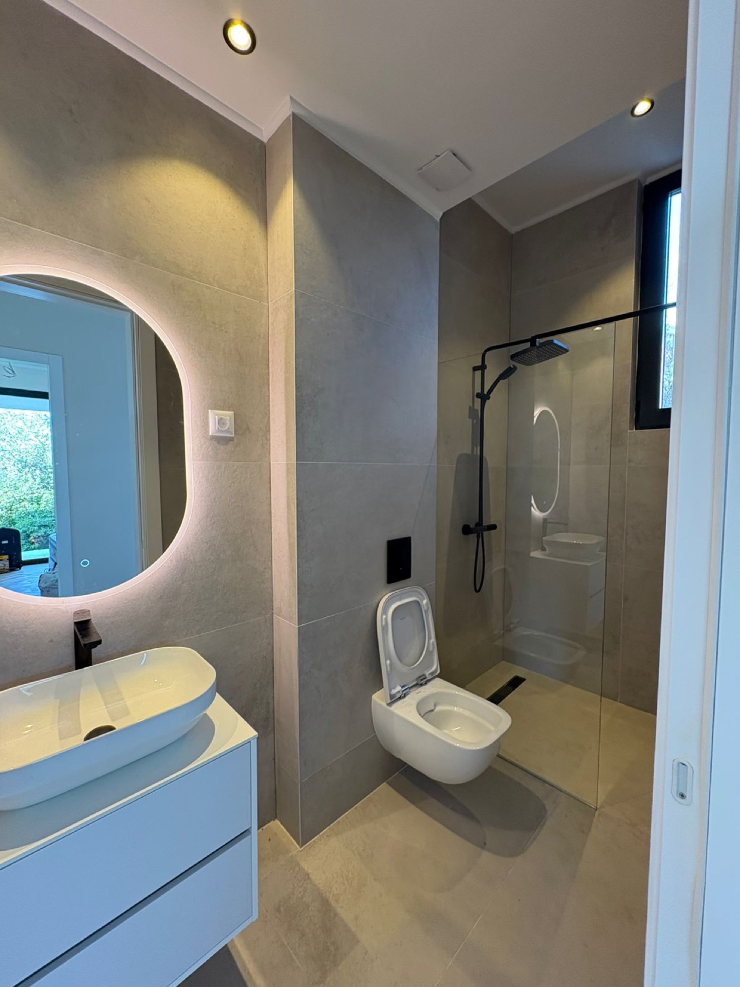 Modern bathroom with a shower cabin and mirror lighting in a residential complex, Herceg Novi, Montenegro.
