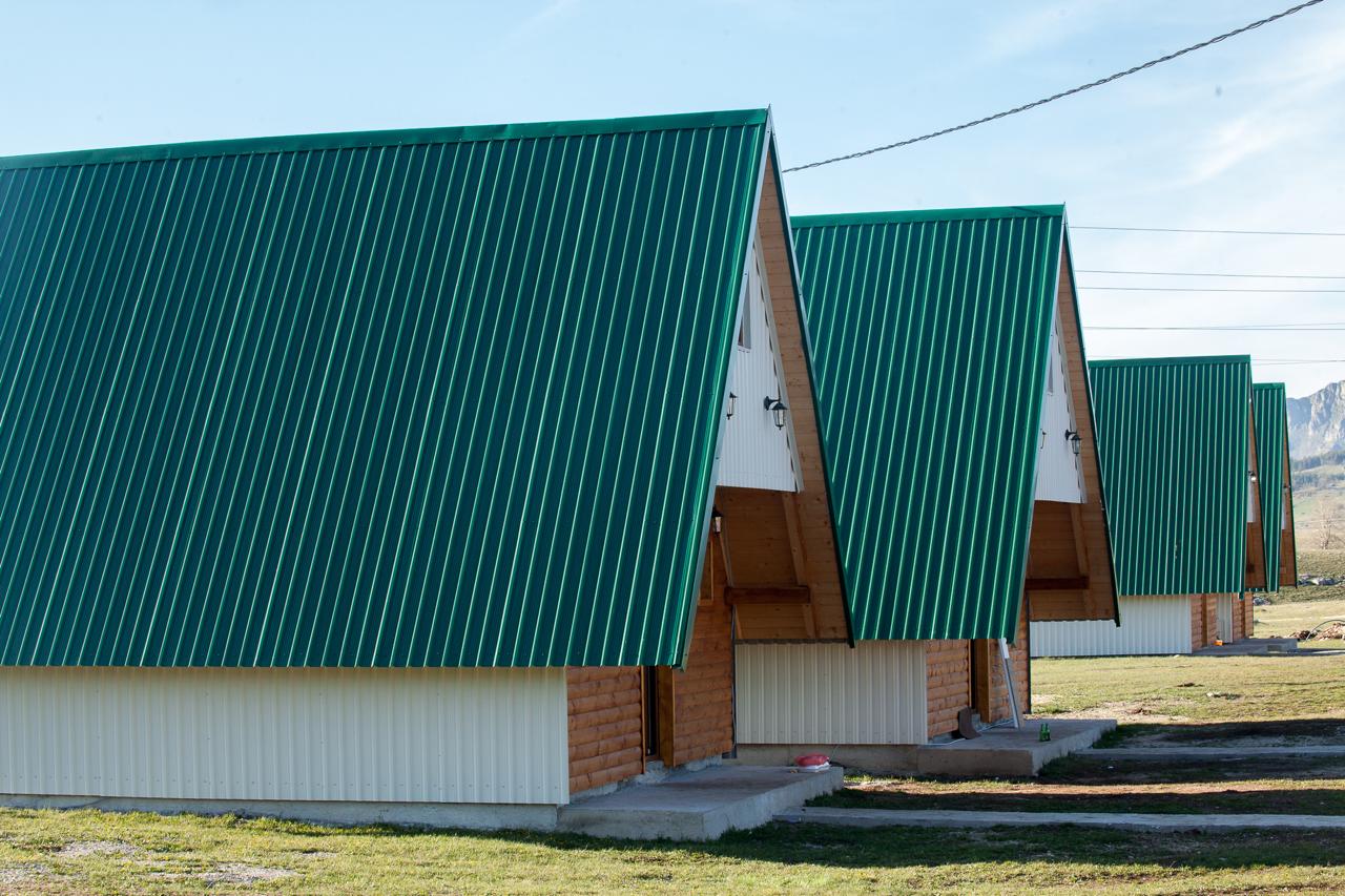 Modern A-frame wooden cabins with green roofs in a mountain complex, Žabljak, Montenegro.