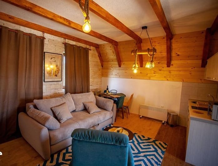 Chalet-style living room with wooden beams in a residential complex, Žabljak, Montenegro: a soft sofa and wooden decor.