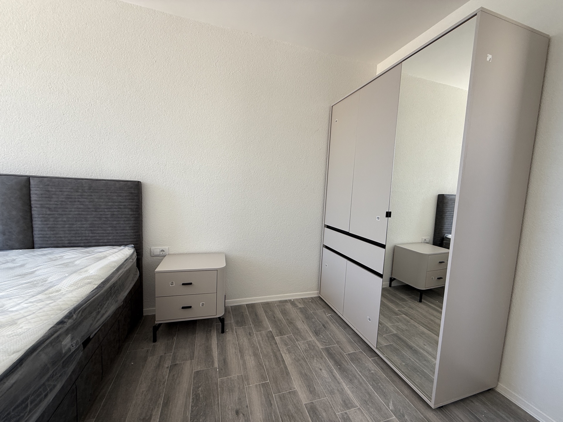 Bedroom in a townhouse in Luštica, Montenegro: double bed, nightstand, and a wardrobe with a mirror.