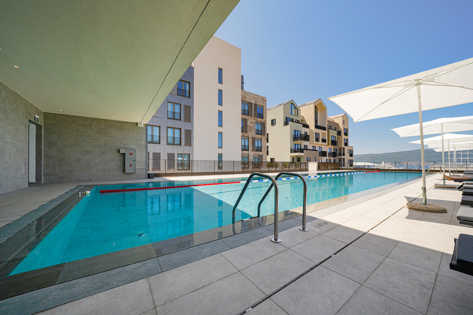 Outdoor pool in the Porto Montenegro complex, Tivat, Montenegro: a modern terrace with sun loungers and sea view.