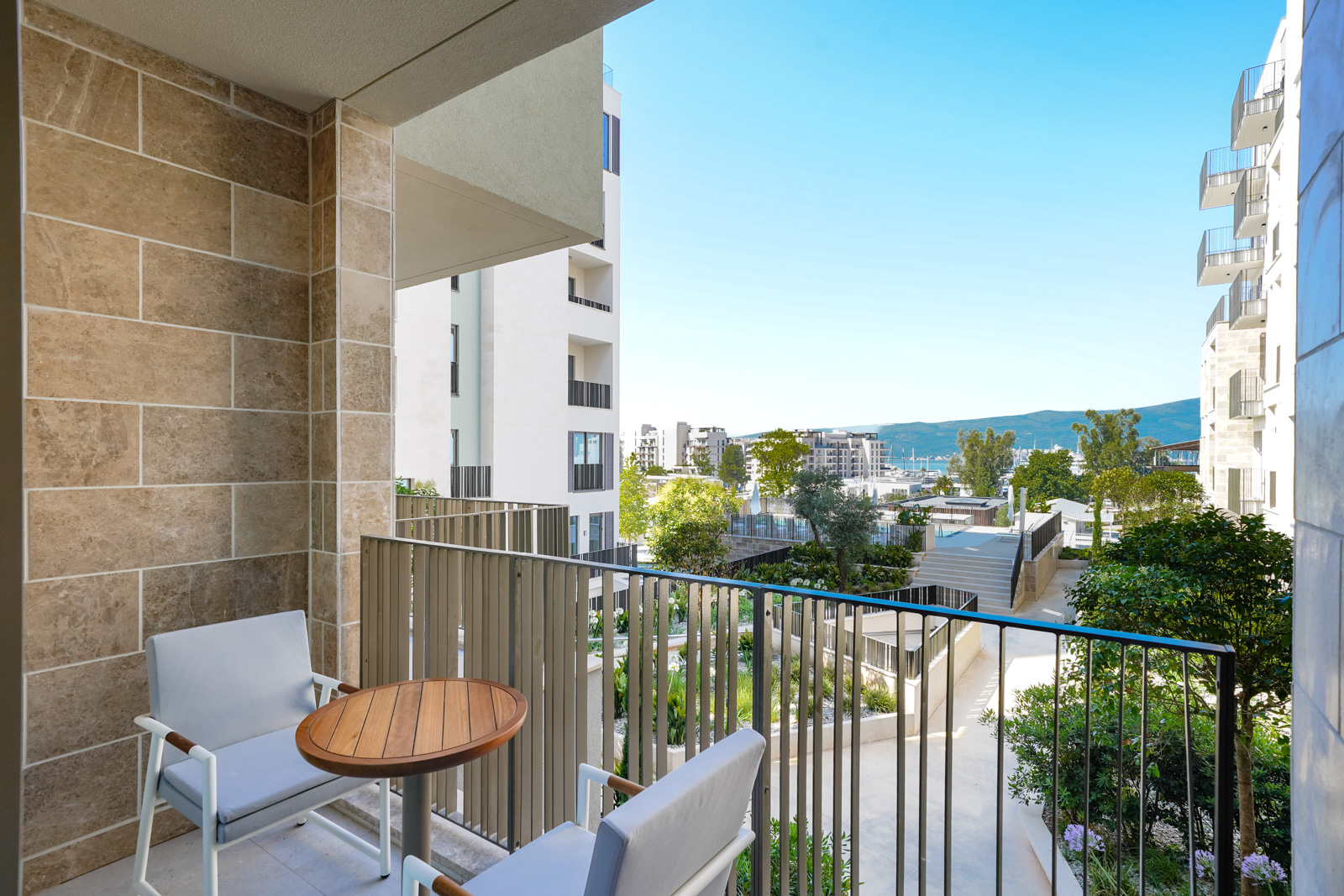 Balcony with furniture in the premium Porto Montenegro residential complex, Tivat, Montenegro: sea, garden, and modern architecture views.