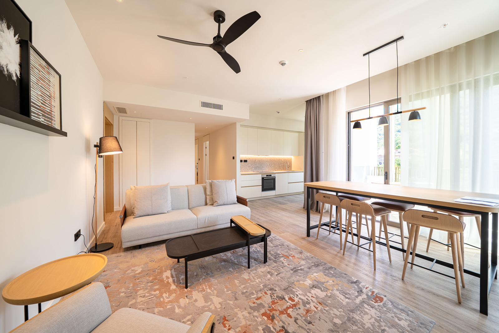 Modern living room with kitchen in an apartment, Porto Montenegro, Tivat, Montenegro: light sofa, dining area, and terrace.