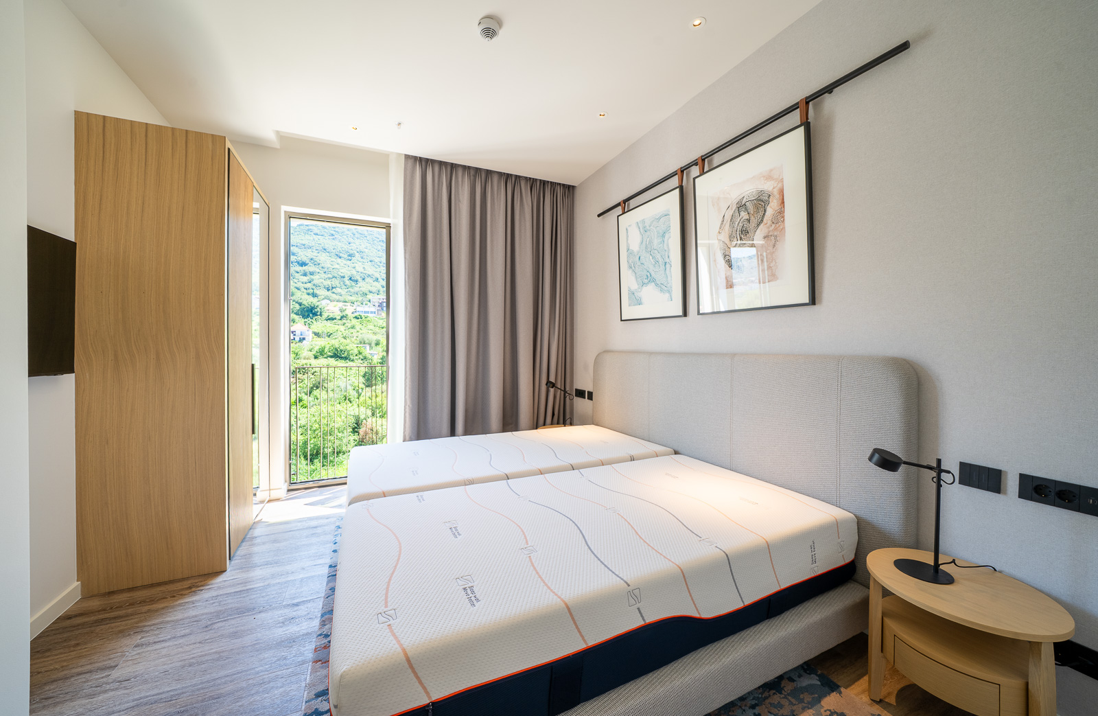 Modern bedroom in an apartment in Porto Montenegro, Tivat, Montenegro: double bed, mountain view, and balcony.