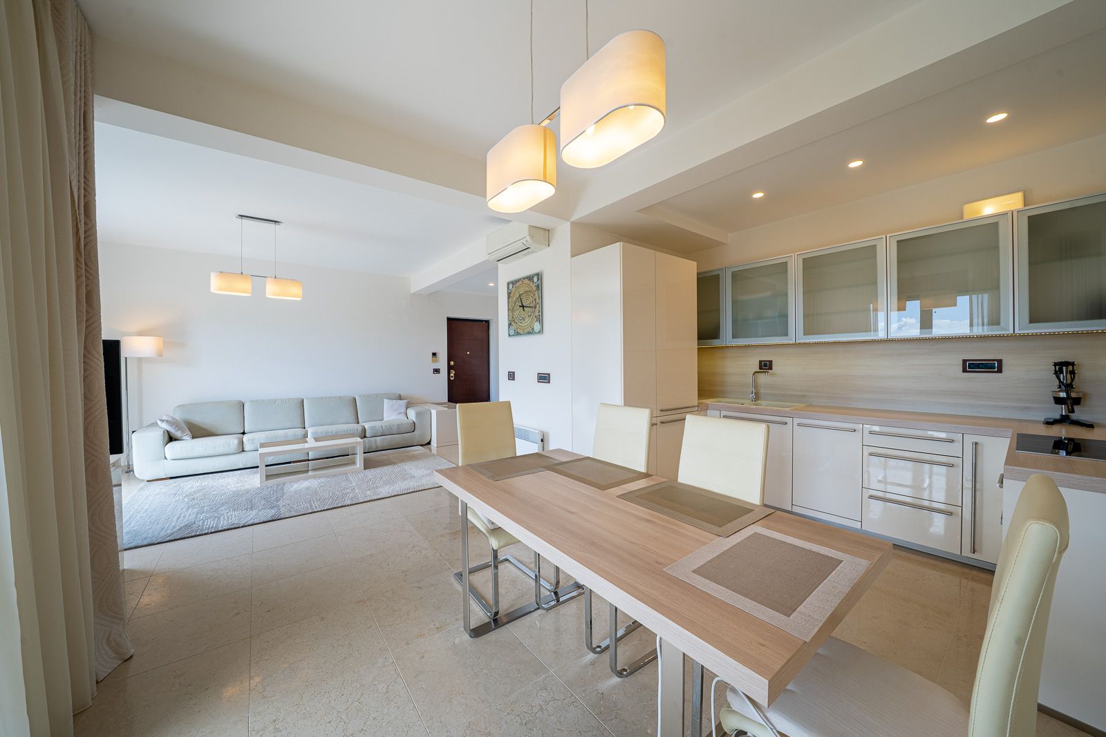 Modern living room with kitchen in an apartment in Petrovac, Montenegro: light furniture, dining area, and stylish interior.