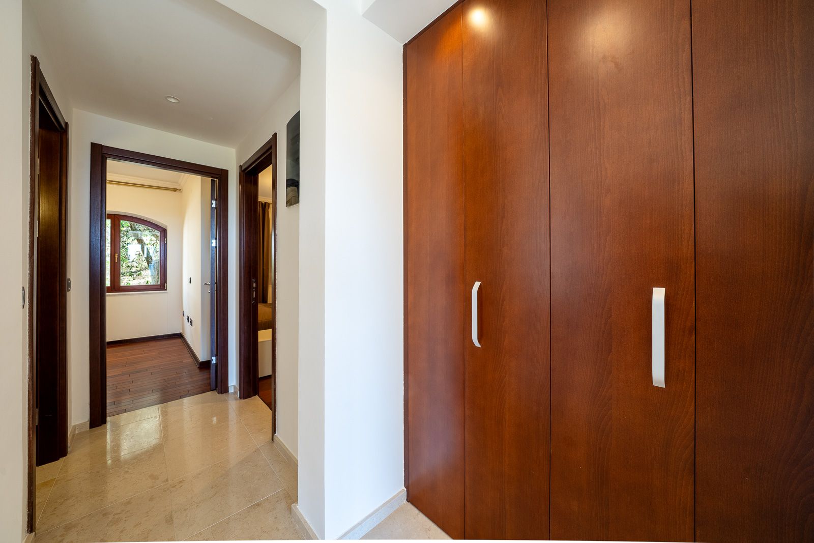 Hallway with a large built-in wardrobe and light flooring in an apartment in Petrovac, Montenegro. View of adjoining rooms.