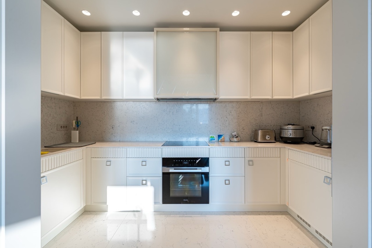 Modern white kitchen with a marble countertop in an apartment in Porto Montenegro, Tivat, Montenegro.