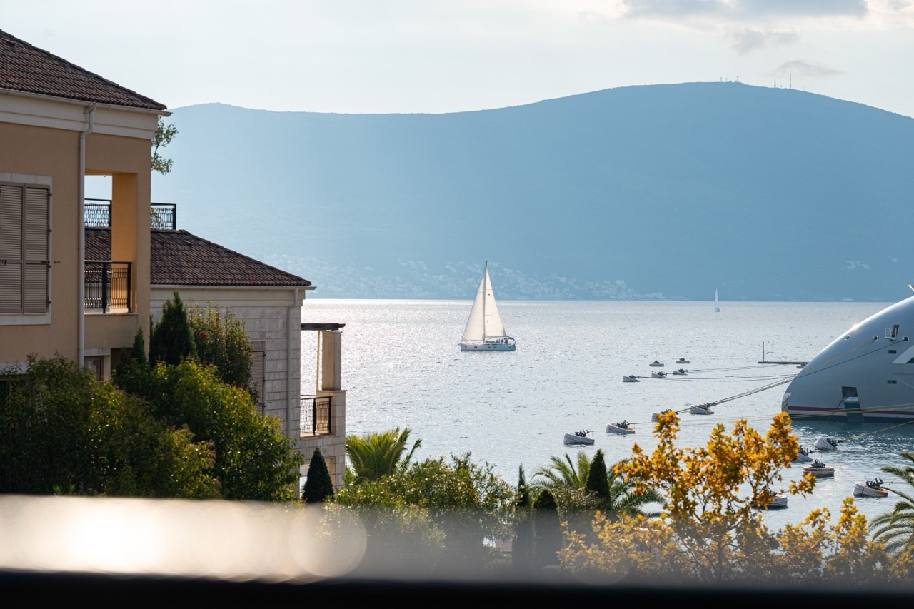 Sea and yachts view from a luxury apartment in Porto Montenegro, Tivat, Montenegro: terrace, mountains, and yacht pier.
