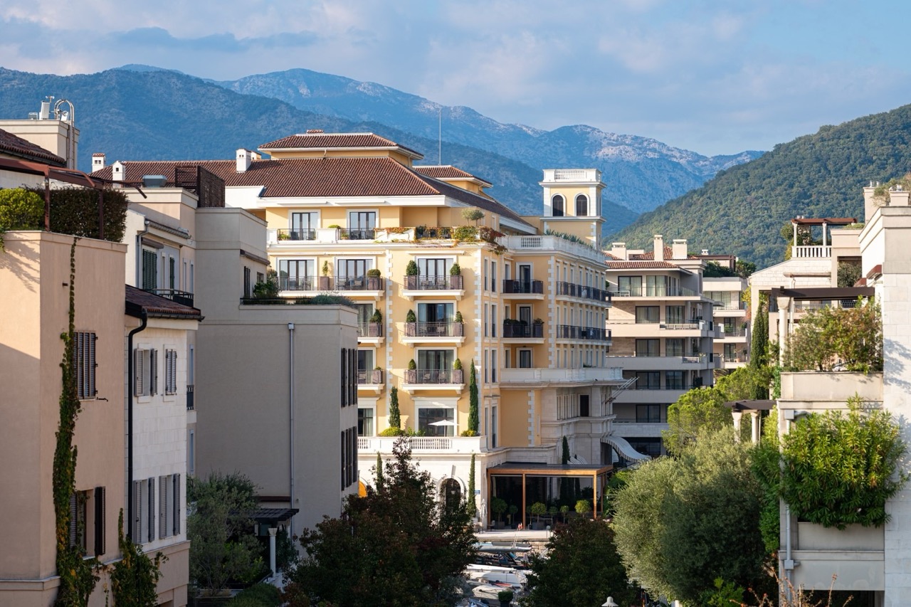 View of a luxury residential complex in Porto Montenegro, Tivat, Montenegro, with terraces and panoramic mountain views.