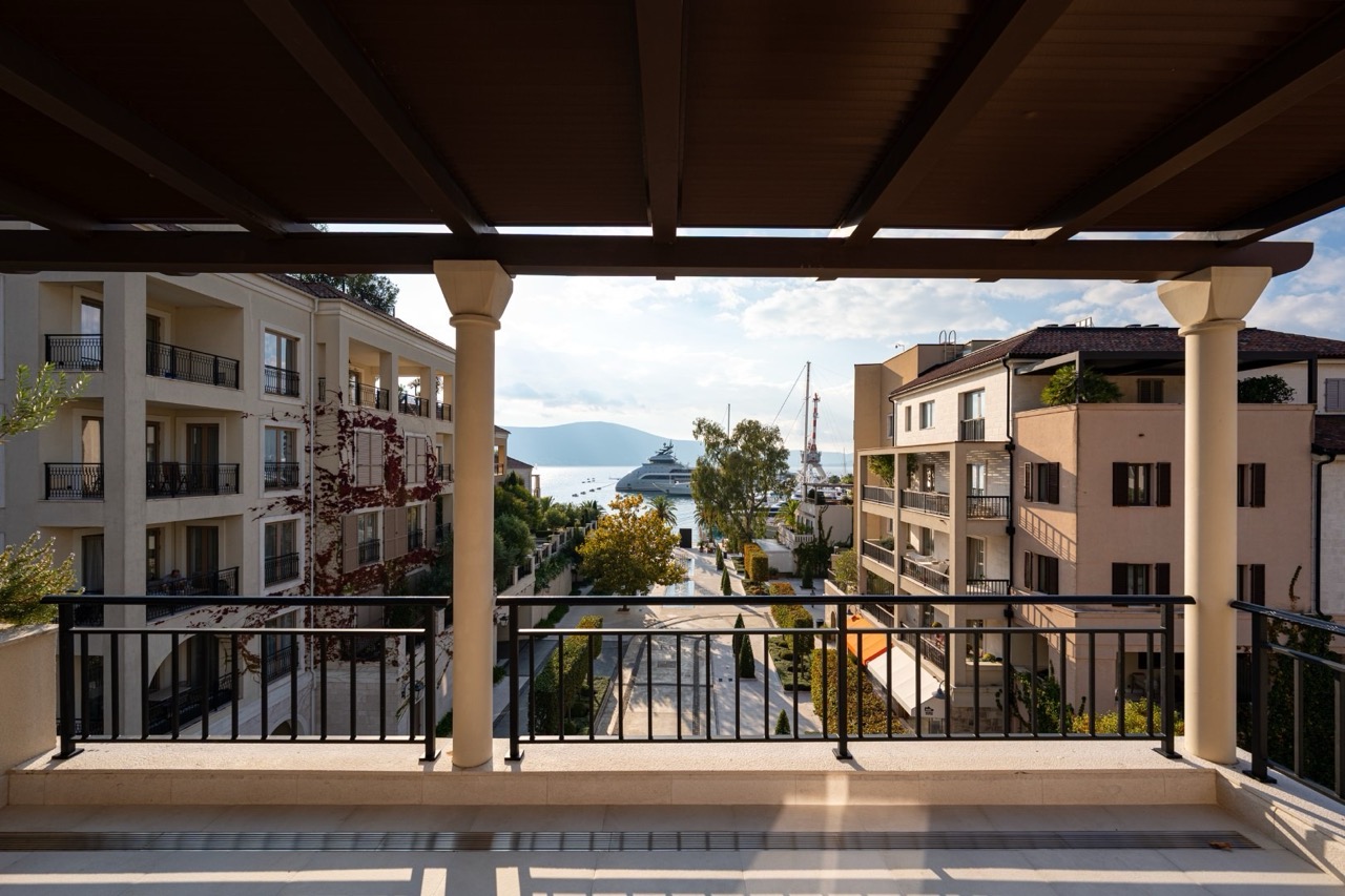 View from the apartment balcony in Porto Montenegro, Tivat, Montenegro: a panorama of the marina with yachts and an upscale residential complex.