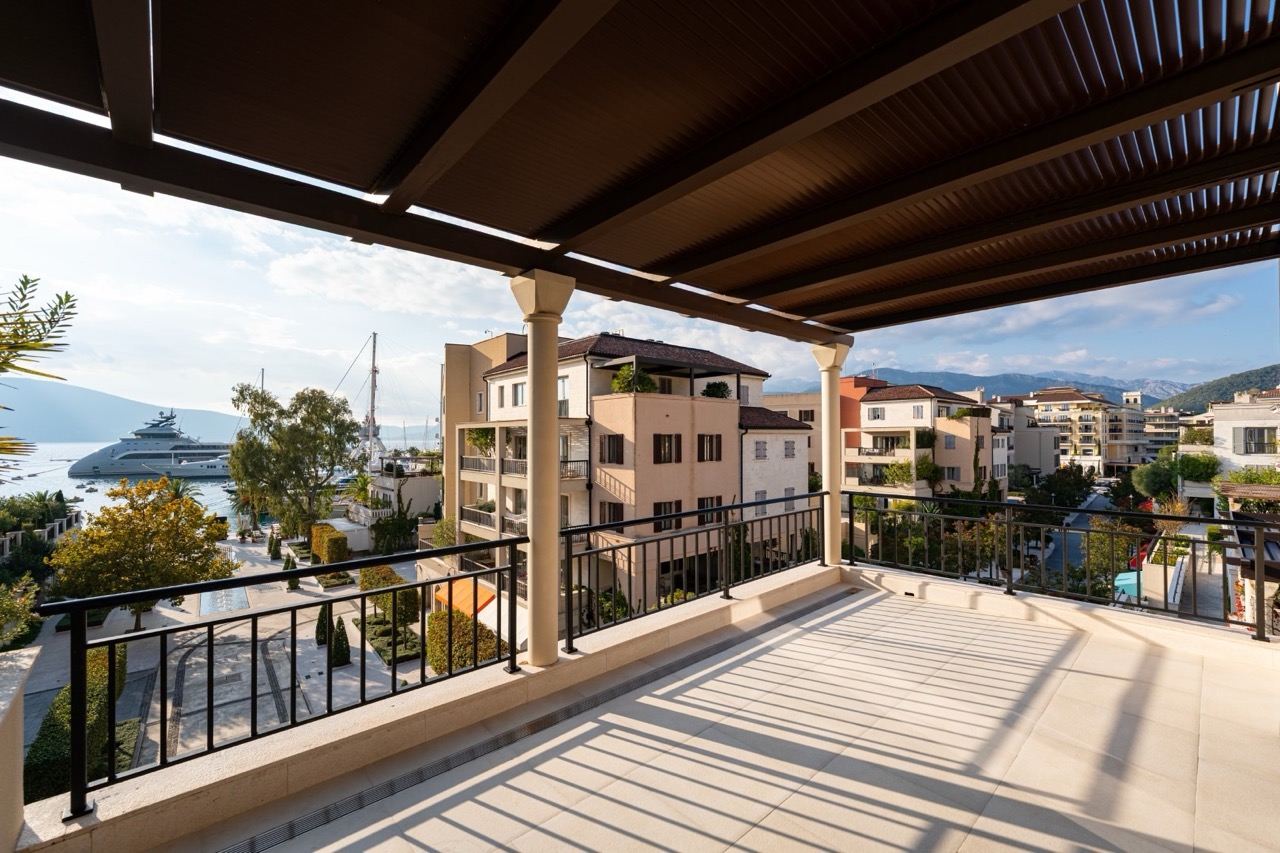 Spacious covered terrace in Porto Montenegro, Tivat, Montenegro, with views of the marina and luxury residential complexes.