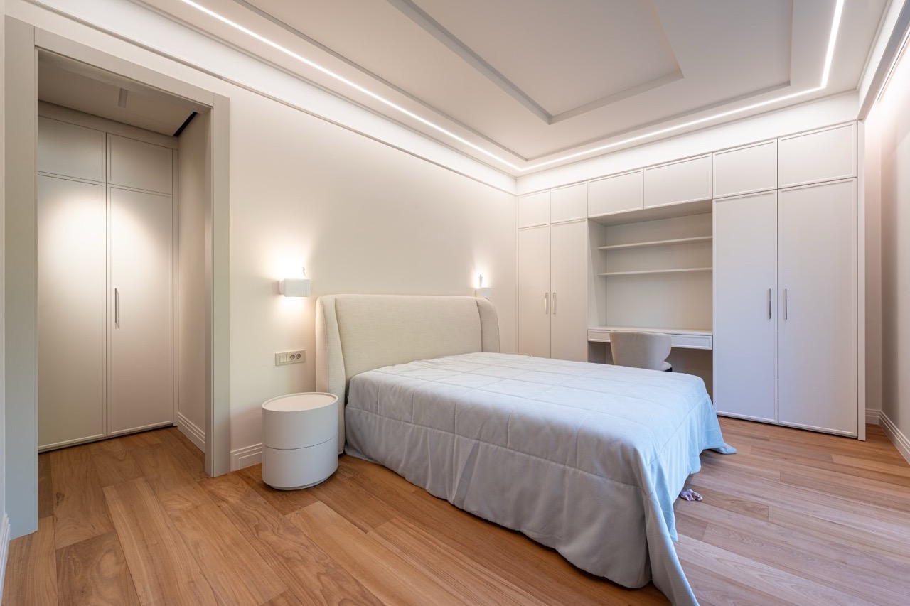 Modern bedroom with a double bed and built-in wardrobe in an apartment in Porto Montenegro, Tivat, Montenegro.