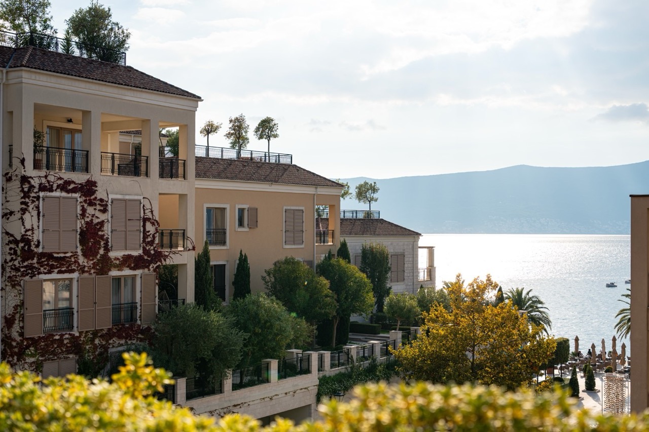 Luxury apartments in Porto Montenegro, Tivat: view of the residential complex with terraces, greenery, and the sea in Montenegro.
