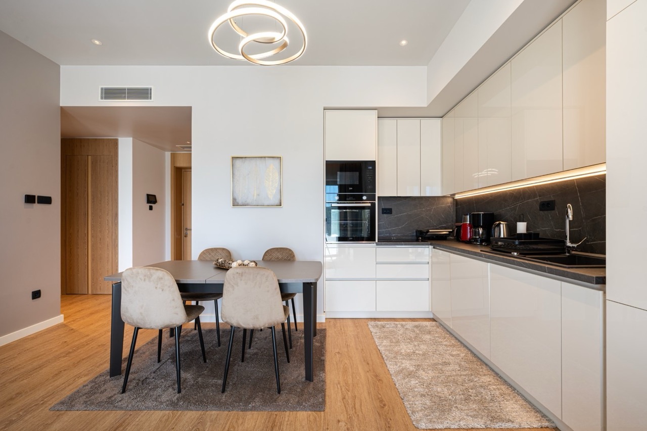 Modern kitchen-dining room in an apartment in Porto Montenegro, Tivat, Montenegro: glossy cabinetry, dining area.
