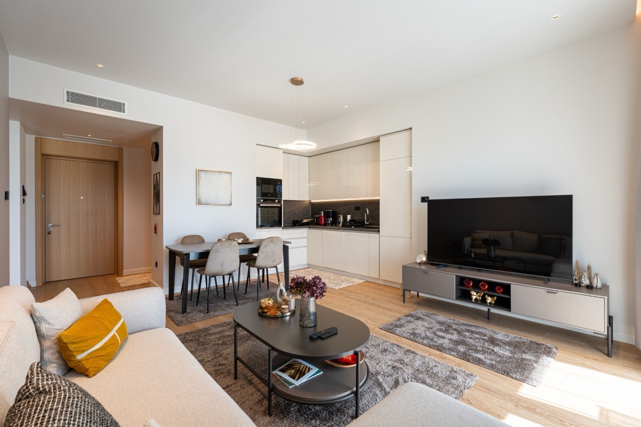 Modern living room with kitchen in an apartment, Porto Montenegro, Tivat, Montenegro: bright interior, furniture, and TV area.