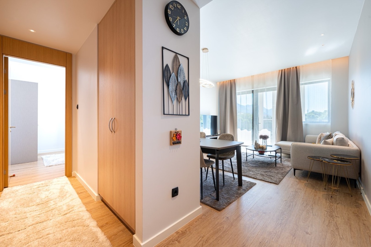 Modern living room with dining area in an apartment in Porto Montenegro, Tivat, Montenegro: bright interior and panoramic windows.