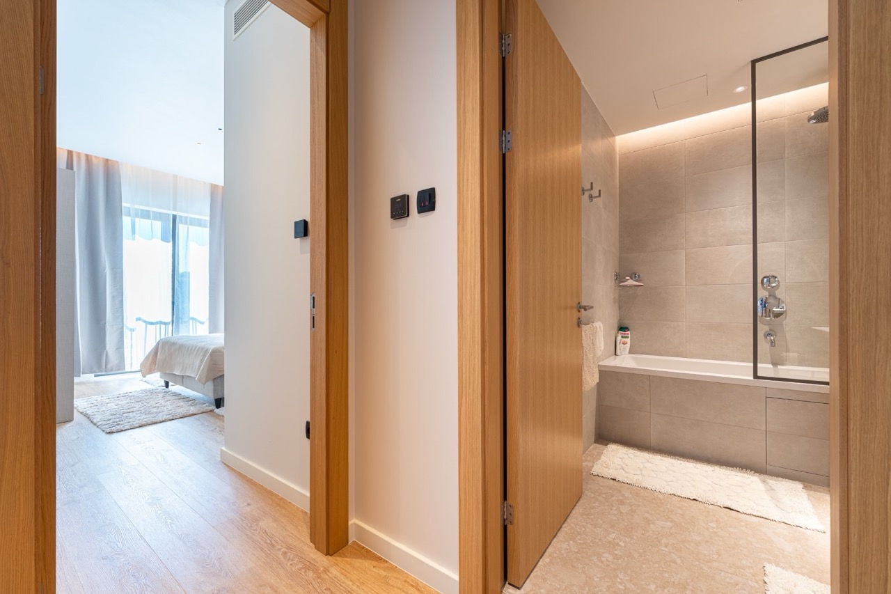 Modern bathroom and bedroom in an apartment, Porto Montenegro, Tivat, Montenegro: stylish interior with oak finishes